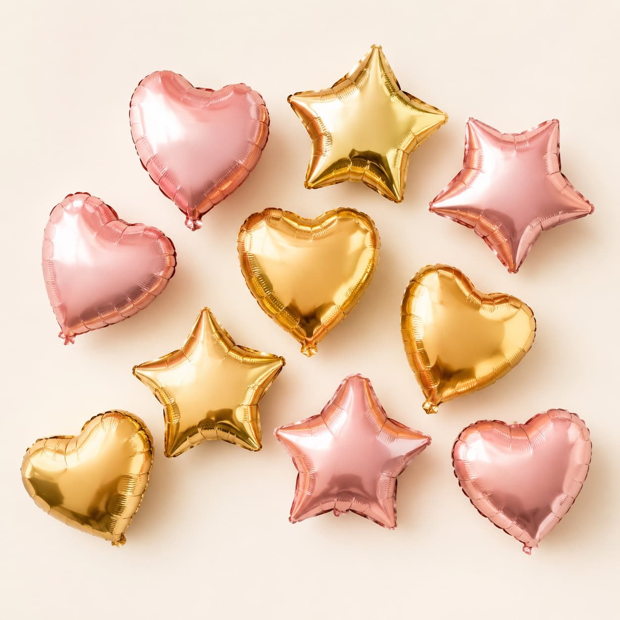 Star & Heart Foil 10-Pack — Ten gold and blush star and heart foils to lift a garland or float a backdrop — air-filled.